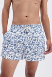 White Swim Shorts with 'Le Bel Été' print, a stylish collaboration by Edith Carron.